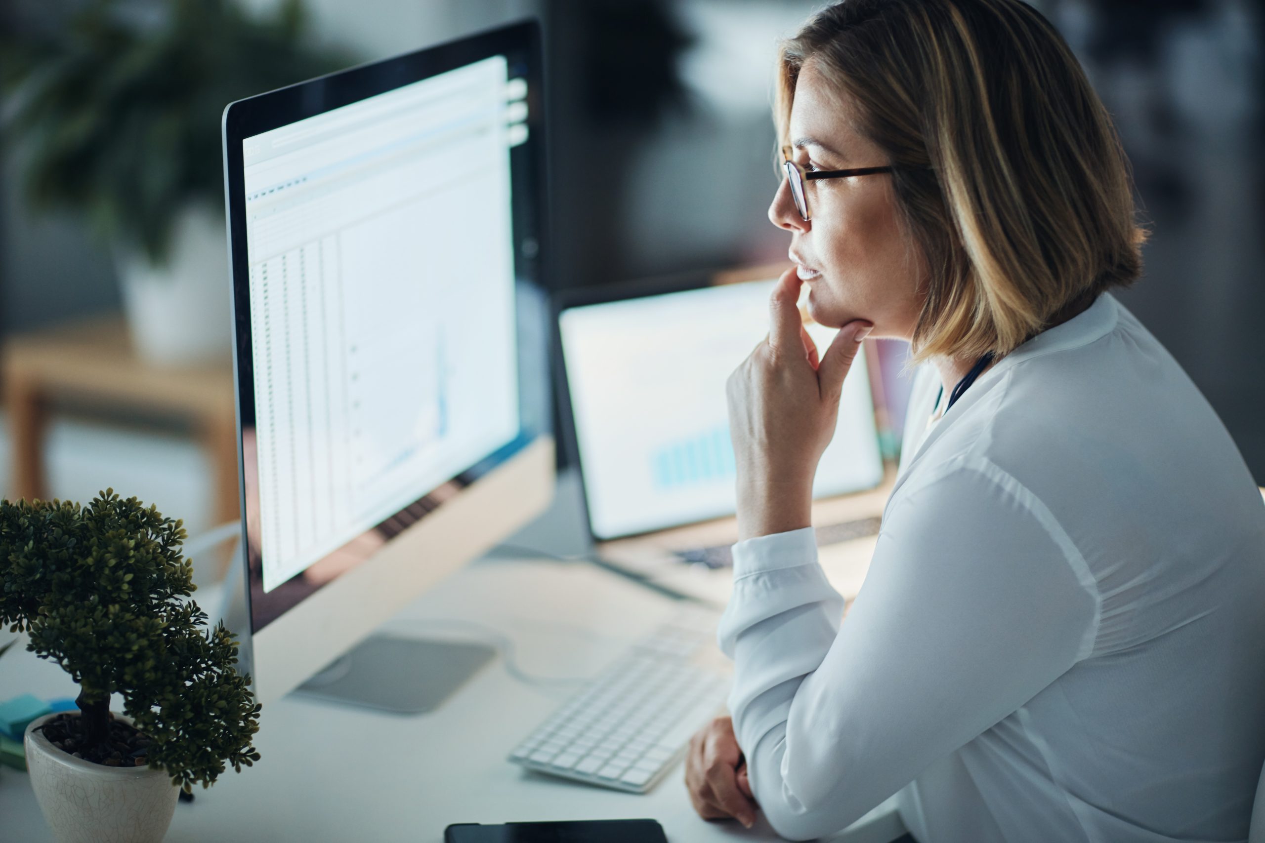 Business, night and woman with focus, computer and check details for a new project, feedback and review. Female person, employee or consultant with a pc, evening or technology for planning with ideas