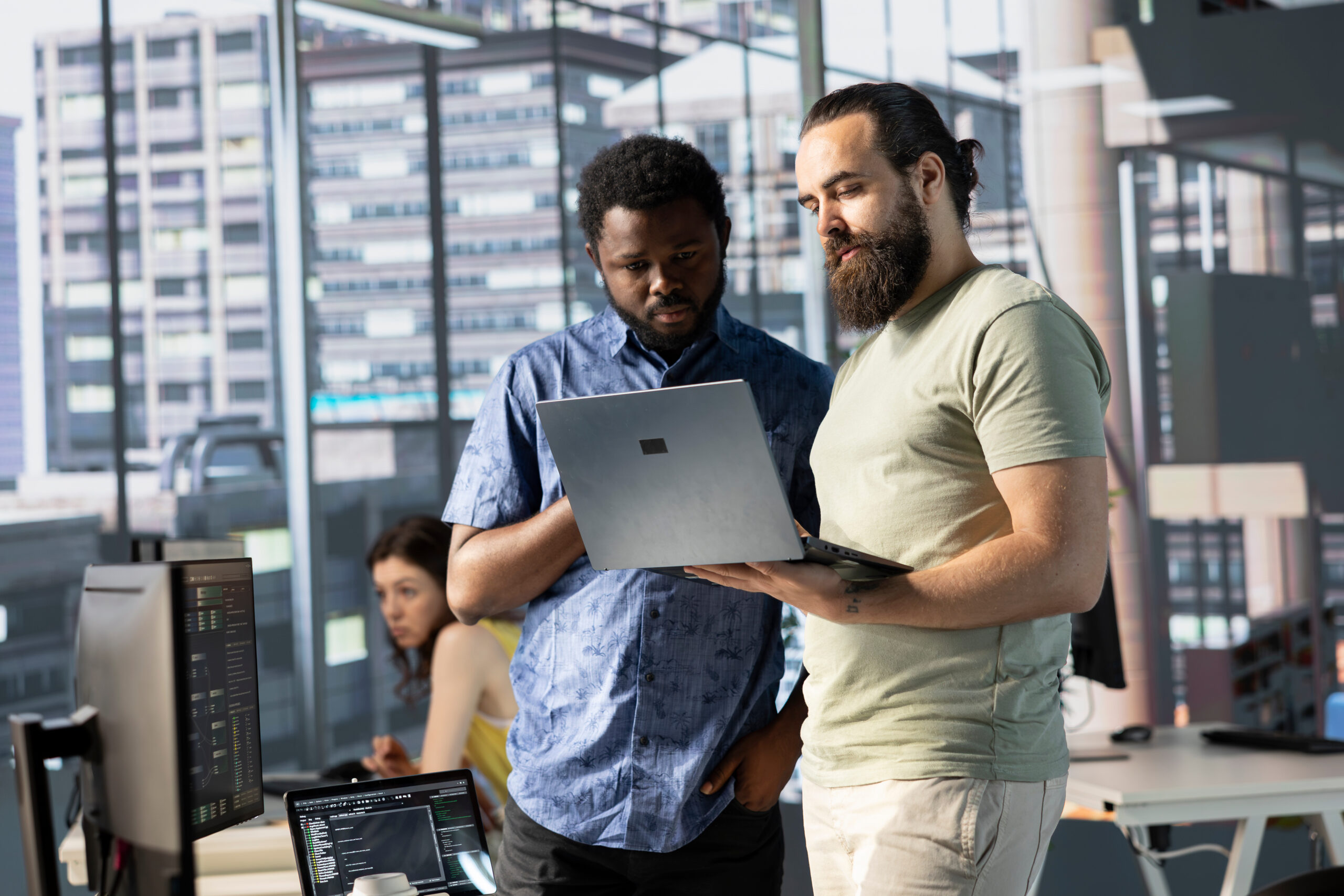 IT specialists in office working together using laptop, testing programs